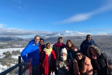 Jeremy Freeman, Class of 1996, director of events at the Olympic Regional Development Authority in Lake Placid, stands with St. Lawrence international students 