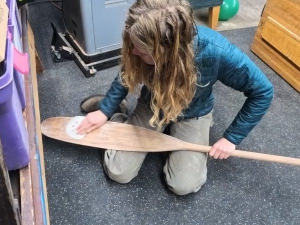 Hannah sanding her paddle for use.