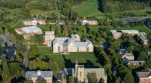 An aerial view of the Saint Lawrence University campus on a sunny day. The campus buildings are surrounded by lush green grass. 