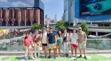 A group of Saint Lawrence students stand in a group and pose in front of a large city while studying abroad.